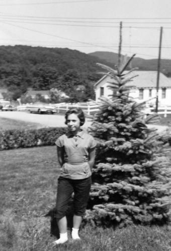 Arlene in front of the blue spruce in Monroe, NY.
